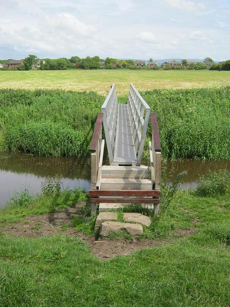 O1 Metal Footbridge With Timber Rails & Concrete Steps Over Broad Fleet In Field